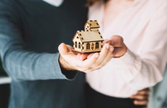 Cele mai ieftine și cele mai scumpe asigurări de locuințe obligatorii pentru împrumuturile bancare cuplu tinand in mana o casa de jucarie